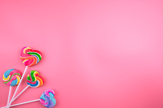 Multicolored lollipops on a pink background