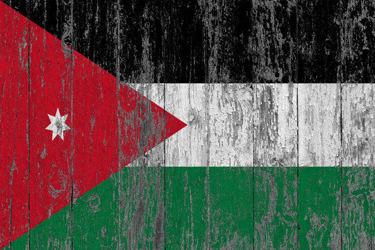 Flag of Jordan painted on worn out wooden texture background.