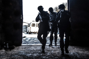 Police special operations group breaching the door - obrazy, fototapety, plakaty
