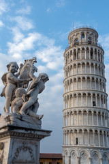 PISA, TUSCANY/ITALY  - APRIL 17 : Statue of cherubs in front of the Leaning Tower of Pisa Tuscany Italy on April 17, 2019. Three unidentified people