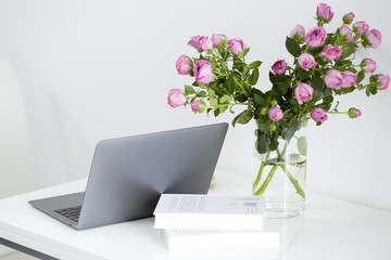 Modern white office desk table with laptop and office supplies