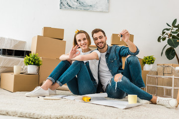 smiling woman showing okay sign while husband showing keys