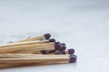 a pile of matches close up on a white table. Macro fire igniter on blurred background