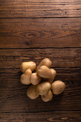 Heap of fresh clean potatoes on rustic wooden surface. Organic food, carbs, tubers.