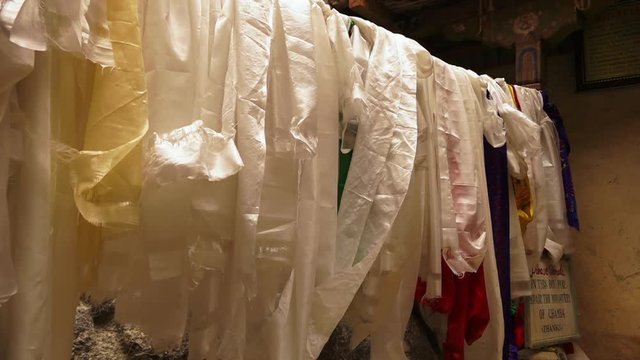 Close up side view still shot of wrinkled religious Khata scarfs hang on a string at Mulbekh monastery, Leh-Ladakh road.
