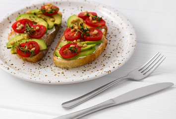 Healthy sandwiches with cream cheese avocado, tomatoes and thyme.