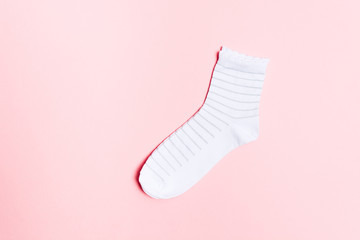 New white socks for feet with shiny striped pattern over pastel pink background with copy space