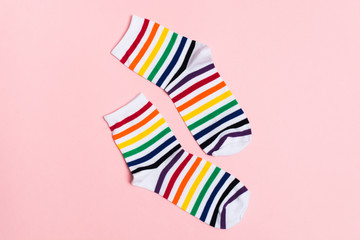 Two colorful striped socks on pink background with copy space. New fresh clothes. shopping concept