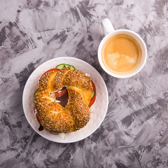 Beautiful and healthy food - a vegetarian sandwich with vegetables and cheese in a bagel