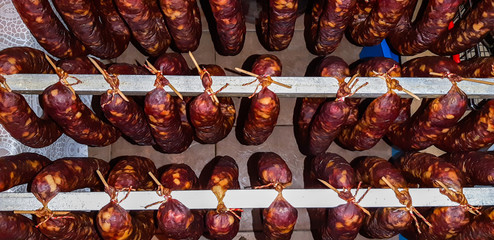 Traditional Slovenian pork sausages called Krajnska klobasa hanged on pole.