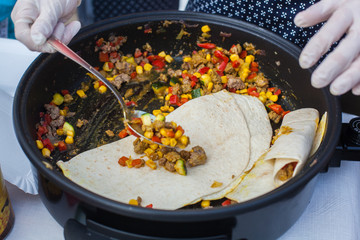 Filling tortillas with vegetables and meat
