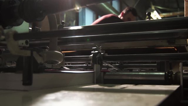 Young Blurred Male Typography Worker Is Working With A Large Printing Press