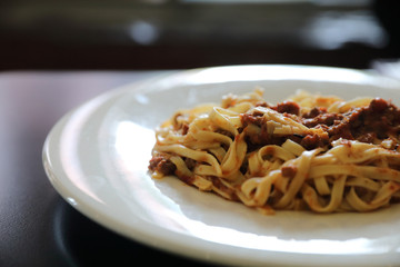 spaghetti Bolognese with minced beef and tomato sauce garnished with parmesan cheese and basil , Italian food