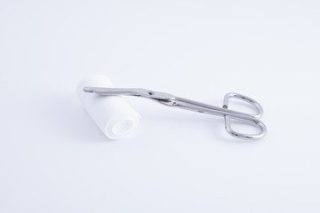 Eine medizinische Schere aus Edelstahl mit Verband über weißem Hintergrund