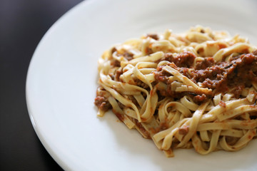 spaghetti Bolognese with minced beef and tomato sauce garnished with parmesan cheese and basil , Italian food