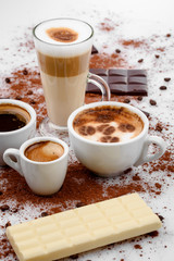 Different types of coffe ,espreso,long coffe ,latte,coffe with milk,on sweet background with coffe beans and chocolate.
