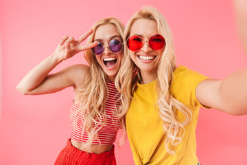 Happy blonde twins in sunglasses making selfie