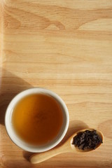 Tea in a white cup on wooden floor, Drink hot tea in the morning with light sunshine..