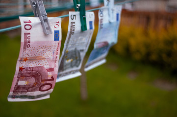 20, 10 and 5 euro banknotes pegged to a garden washing line