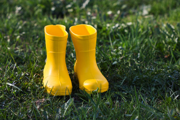 Yellow rubber boots on green grass.