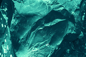 Vintage azure background. Rough painted wall of turquoise color. Imperfect plane of cyan colored. Uneven old decorative toned backdrop of aqzure tint. Texture of teal hue. Ornamental stony surface.