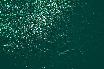 Vintage green background. Rough painted wall of emerald color. Imperfect plane of virid colored. Uneven old decorative toned backdrop of green tint. Texture of emerald hue. Ornamental stony surface.