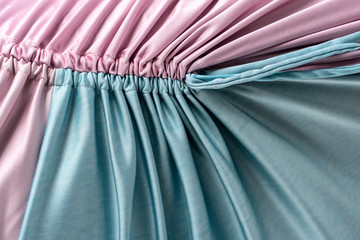 Pink and turquoise color stitched frilly cloth. Closeup material.
