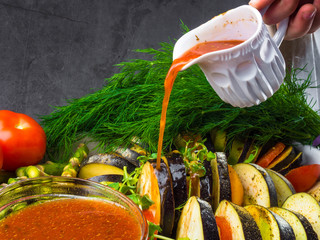 Ratatouille - traditional French Provencal vegetable dish cooked in oven pouring with tomato, olive...