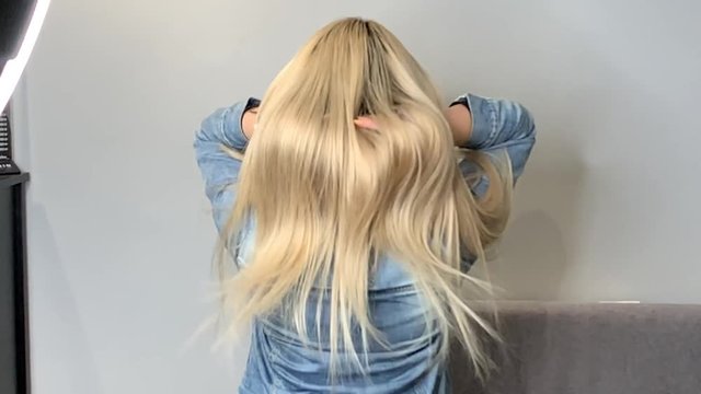 Blonde woman waving her beautiful, healthy hair after a treatment at a beauty salon, before and after. Slow motion