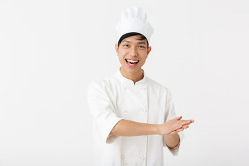 Portrait of happy chinese man in white cook uniform and chef's hat smiling at camera