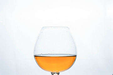crystal glass with brown cognac on white background with copy space