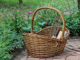 Fototapeta na wymiar large wicker basket on the tiled path in the garden