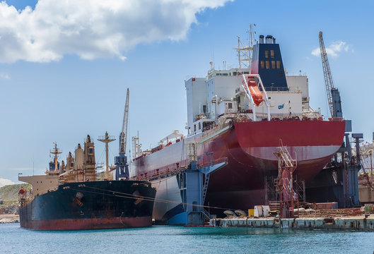 Bulk Carrier On Dry Dock In Shipyard.Heavy lifts cargo ship temporary  laid up next to dry dock. Stock Image.