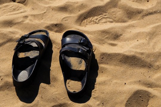 Black sandals on the beach