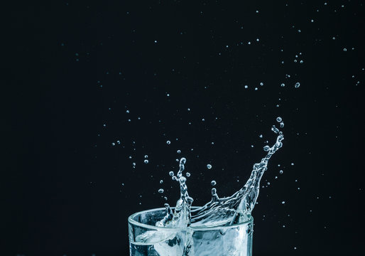 Water splash in glass with black background