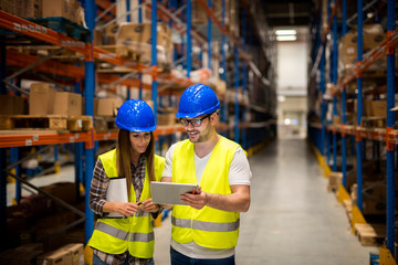 Working together on organizing goods distribution. Workers in large distribution warehouse.