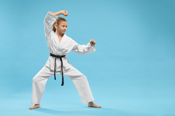 Side view of child standing in karate stance in studio