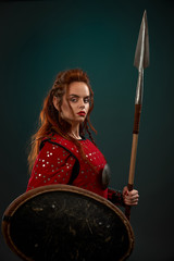Medieval female warrior posing with spear, shield.