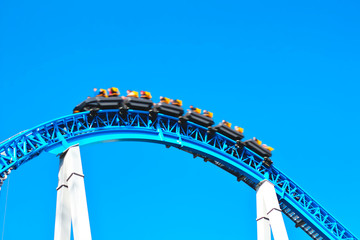People relax, have fun and fast ride the blue spooky scary roller coaster with loop in the...