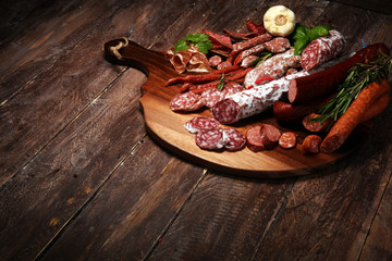 Food tray with cold meat with delicious salami and herbs . Variety of meat products including coppa and sausages