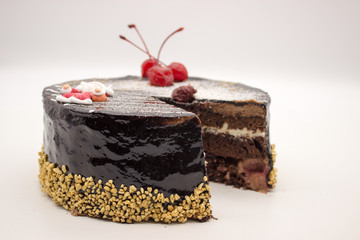 Delicious chocolate cake, decorated cherries, and sugar Santa and crispy nuts, an isolated on a white background. Cake with a copy space area.