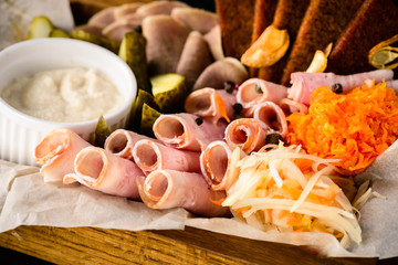 Food tray with delicious salami, pieces of sliced ham, sausage, tomatoes, salad and vegetable
