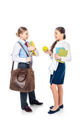schoolgirls in formal wear with books and apple looking at each other and talking On White