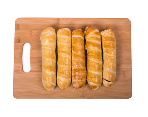 sausages in dough on a wooden board, background is white