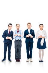 smiling schoolchildren pretending to be businesspeople holding coffee cups and looking at camera On White