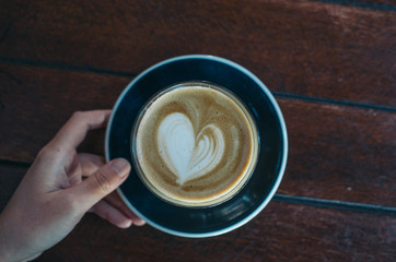 cup of coffee in hand on a red background