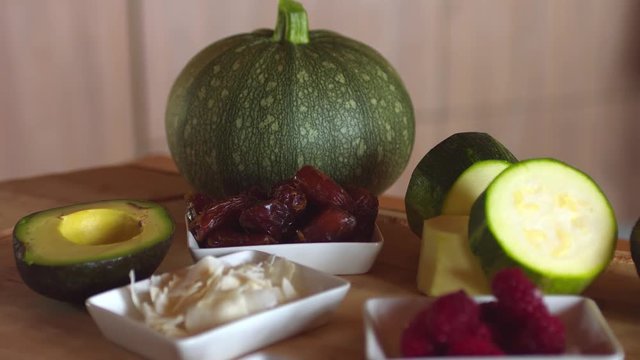 Ingredients to prepare a raw vegan dessert, presented on a wooden table