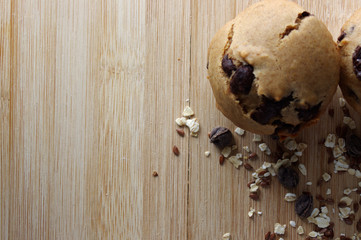 Homemade muffins on wooden table with oats and seeds