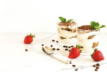 Classic tiramisu, traditional Italian dessert in a glass on a marble table, background.copy space