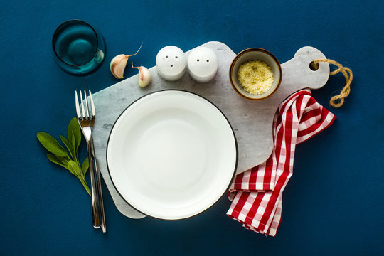 Empty Served Plate On Marble Serving Board And Blue Spice Backgroundi